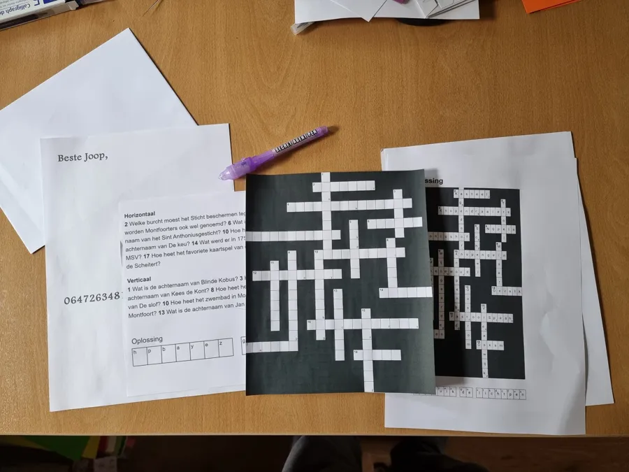 Een uitgeprinte kruiswoordpuzzel met een brief en een paarse pen op tafel