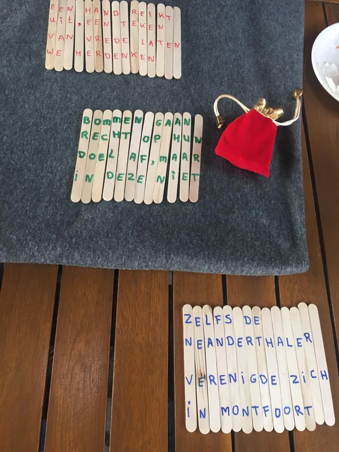 IJslollystokjes met letters, gelegd tot raadselzinnen, naast een rood zakje
